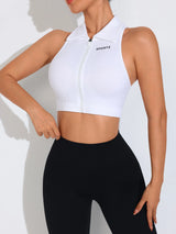 Person wearing a white sports crop top and black leggings on a light background