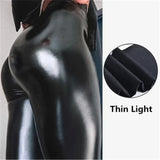 Black shiny leggings worn by a person, with a close-up of the fabric texture on a white background.