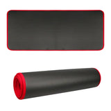 Black yoga mat with red edges on a white background