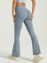 Person wearing light blue flared leggings on a plain background