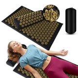Acupressure mat with gold needles, a pillow, and a pump on a white background.