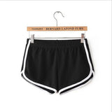 Black shorts with white trim on a hanger against a white background