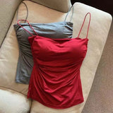 Red and gray tank tops on a beige chair