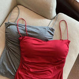 Red dress and gray top on a beige couch