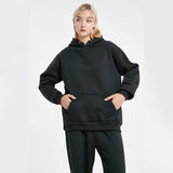 Person wearing a black hoodie and pants on a white background