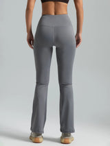 Person wearing gray high-waisted pants on a plain background