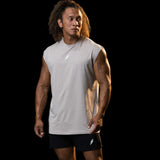 Man wearing a sleeveless athletic shirt and shorts on a black background
