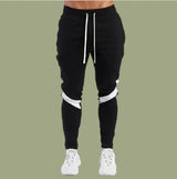 Black jogger pants with white accents on a green background