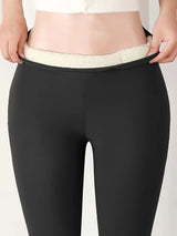 Black leggings with white lining being worn on a plain background