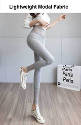 Person wearing gray leggings with text about lightweight modal fabric on a plain background