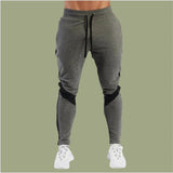Gray jogger pants with black accents on a green background