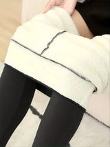 Close-up of a person wearing black leggings with white tights underneath.
