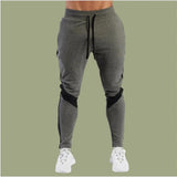 Gray jogger pants with black accents on a green background