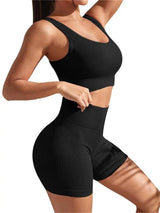 Person wearing a black ribbed sports bra and shorts set on a white background
