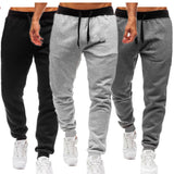 Three pairs of jogger pants in black and gray on a white background