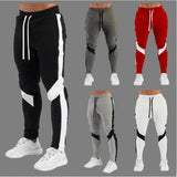 Five pairs of jogger pants in black, gray, red, and white with varying designs on a gray background.