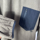 Gray textured jacket with a navy blue zipper pocket