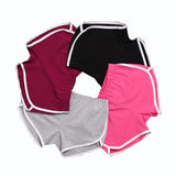 Four pairs of colorful shorts stacked on a white background