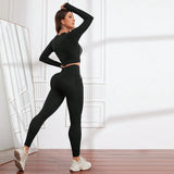 Woman wearing a black athletic outfit in a bright room.