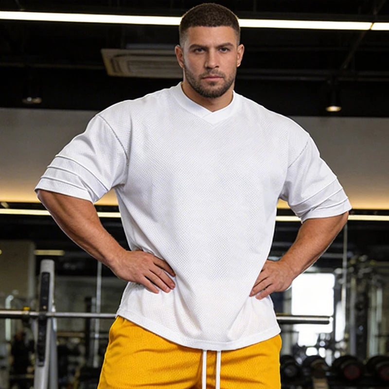 Men’s oversized performance t-shirt by Athletic Sanctuary, quick dry gym essential with breathable fabric, shown in black on a model.