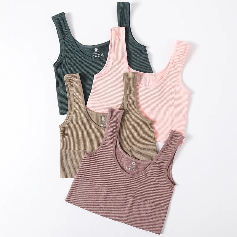 Woman wearing a women's seamless ribbed wireless sports camisole crop top by Athletic Sanctuary, showing front view and fitted design.