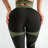 Person wearing black and green patterned leggings on a white background