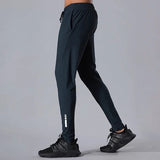 Person wearing black athletic pants and shoes on a gray background